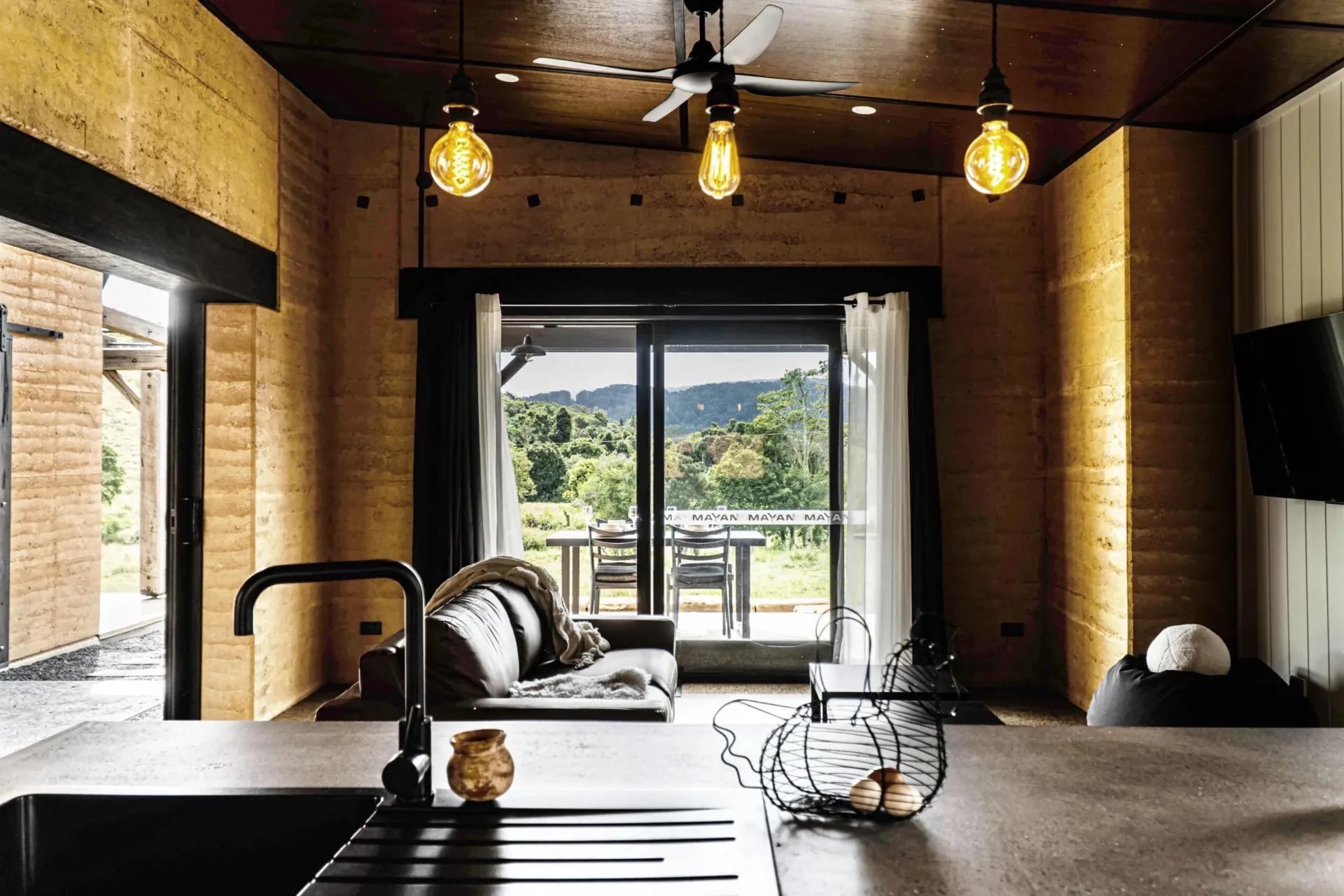 Villa interior with rammed-earth walls and open outlook