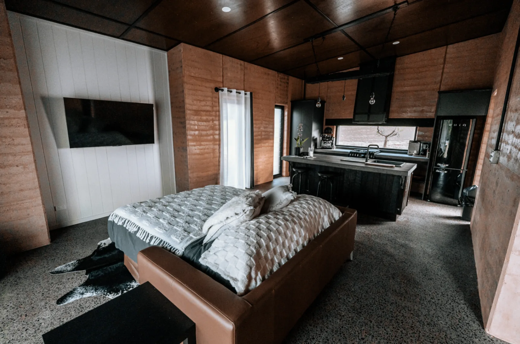 Open-plan villa interior with bed and kitchen